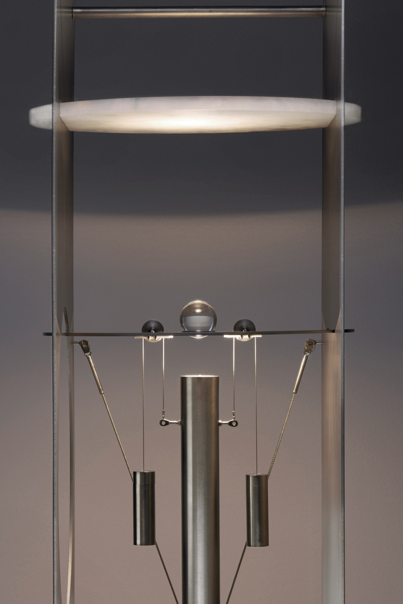 kinetic lighting activates mechanical movement in a sculpture of steel and glass