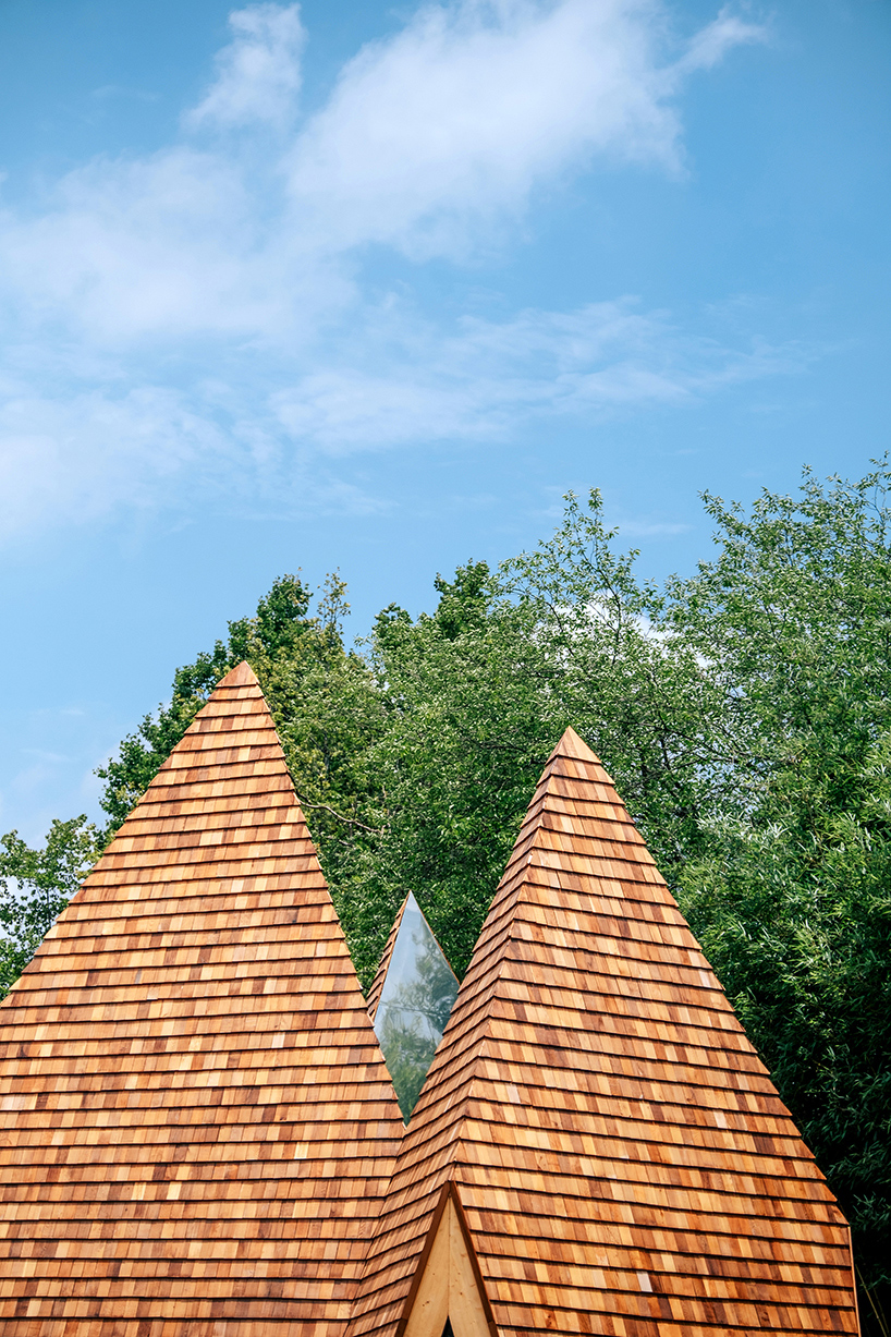 wooden shingles overlay cluster of monolithic cabins on chinese waterfront