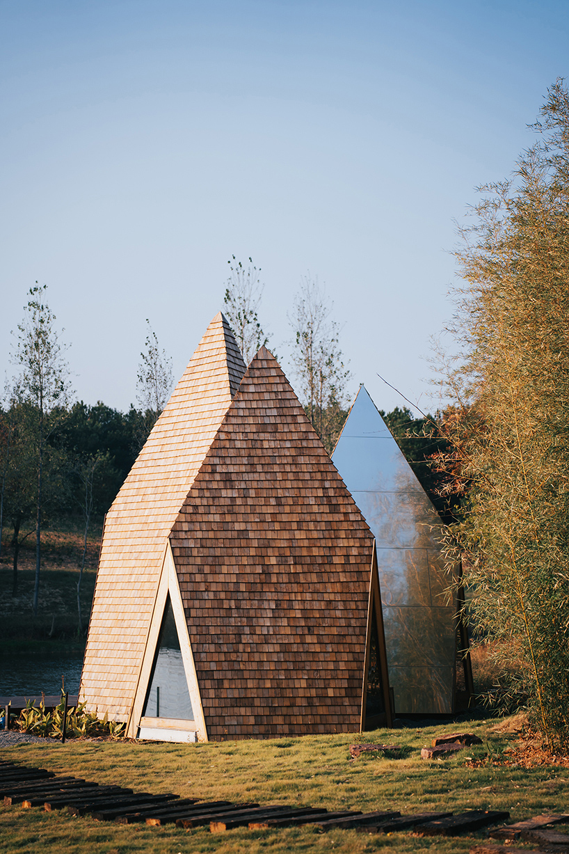 wooden shingles overlay cluster of monolithic cabins on chinese waterfront