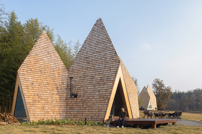 wooden shingles overlay cluster of monolithic cabins on chinese waterfront