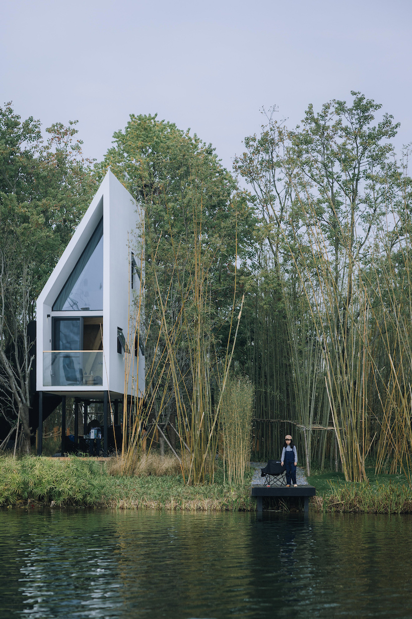 wood-clad cabins by wiki world stand on stilts like sailboats along wuhan's shoreline