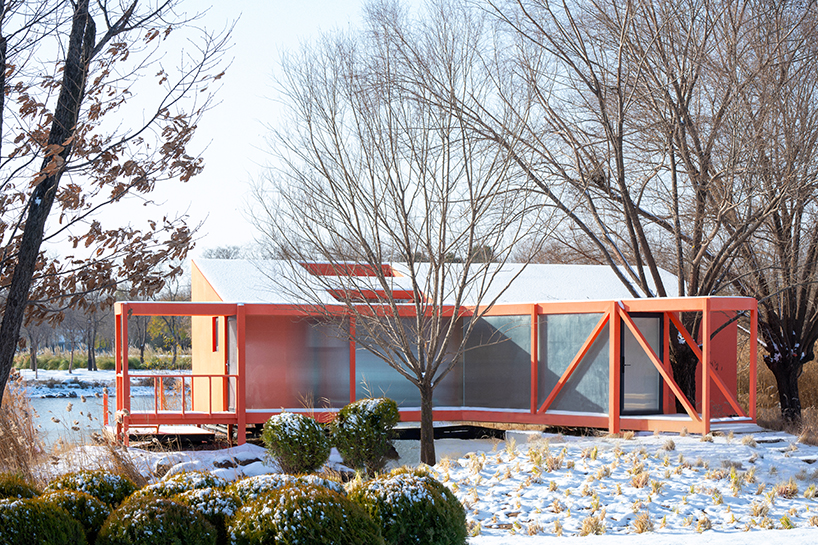 playful crimson timber cabin floats above a stream in chinese cultural park - 4