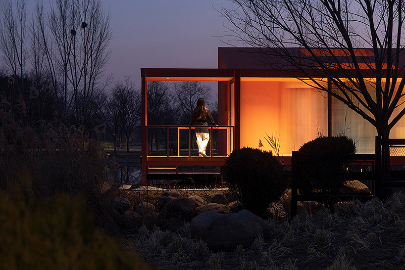 playful crimson timber cabin floats above a stream in chinese cultural park - 12