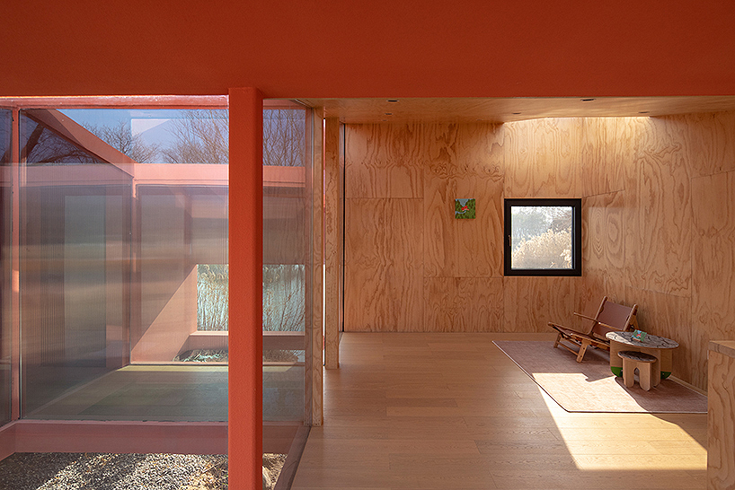 playful crimson timber cabin floats above a stream in chinese cultural park - 11