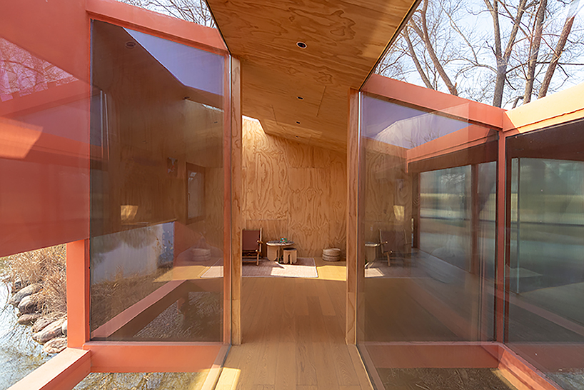 playful crimson timber cabin floats above a stream in chinese cultural park - 5