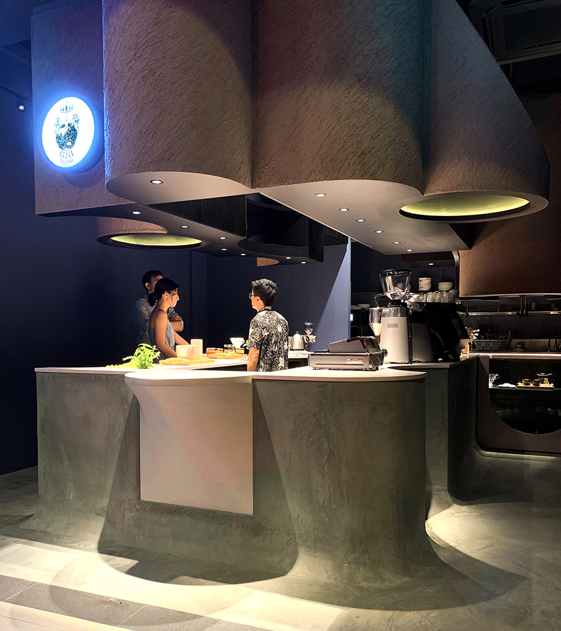 studio SKLIM's 'voids cafe' in singapore is carved out of a monolithic concrete block