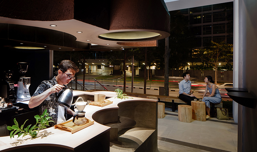 studio SKLIM's 'voids cafe' in singapore is carved out of a monolithic concrete block