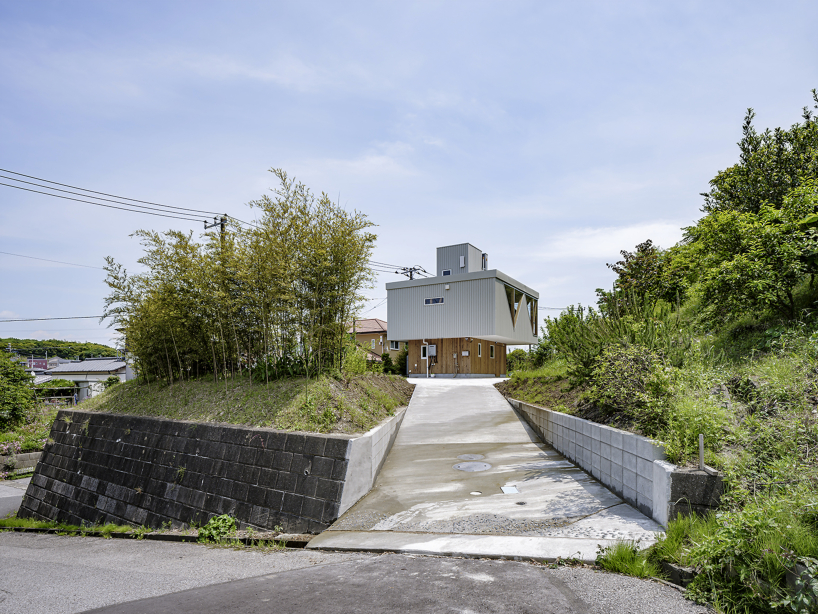 angular apertures cut through the wooden cantilever of residence in japan
