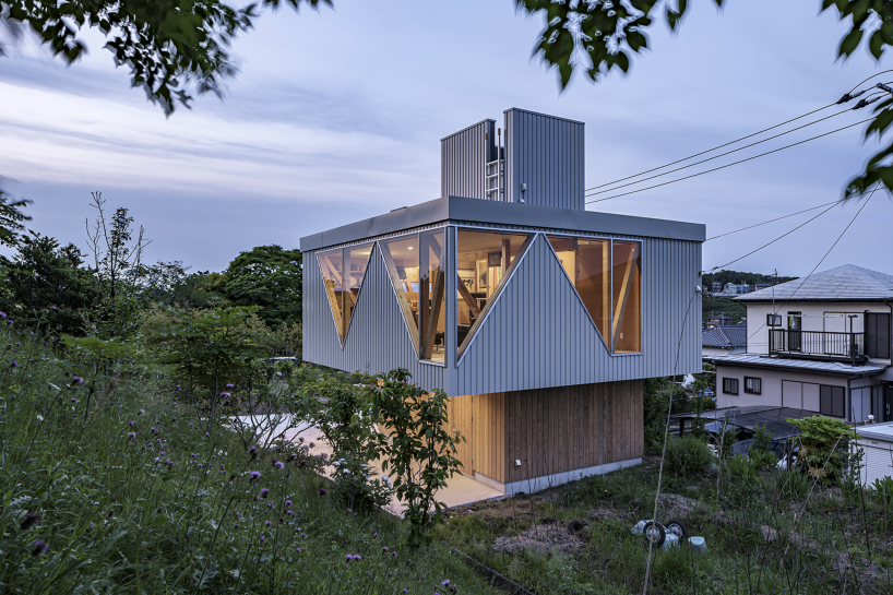 angular apertures cut through the wooden cantilever of residence in japan