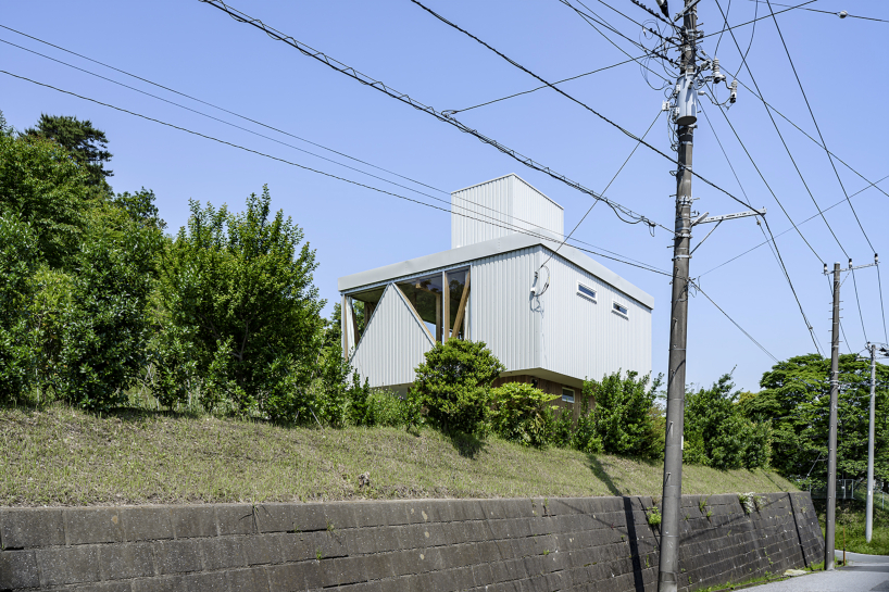 angular apertures cut through the wooden cantilever of residence in japan
