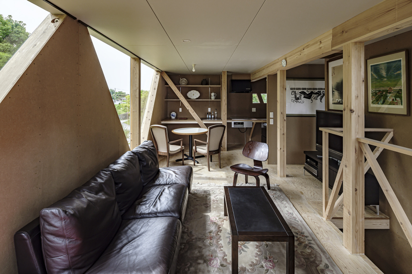 angular apertures cut through the wooden cantilever of residence in japan