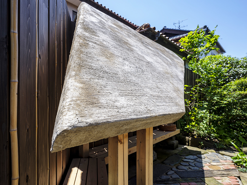 moss-covered earthen roof shields teahouse’s waiting area in japan
