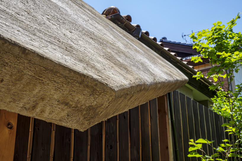 moss-covered earthen roof shields teahouse’s waiting area in japan