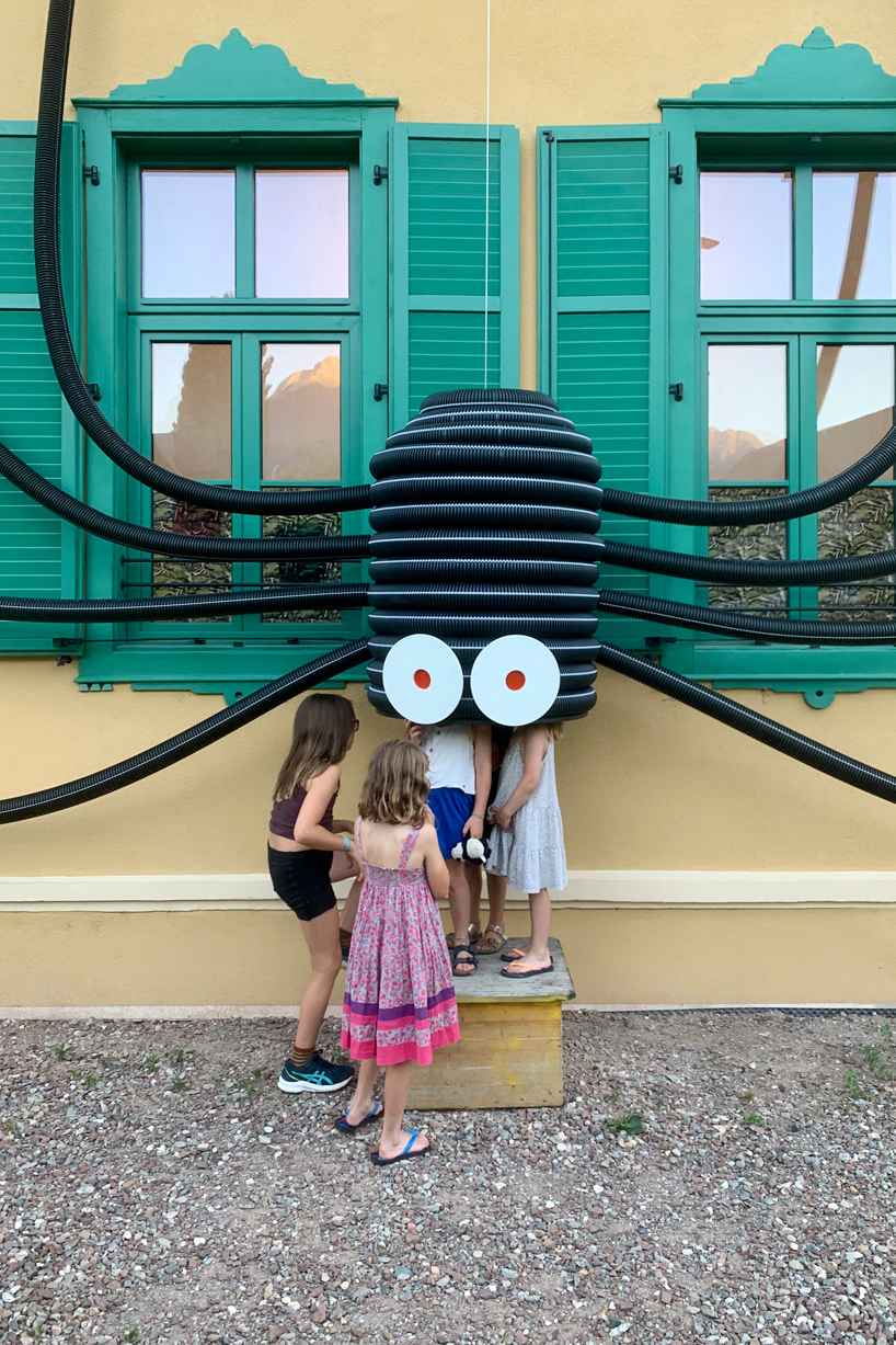 moradavaga's spider sprawls across facade in italy, reminiscent of an old-school string phone