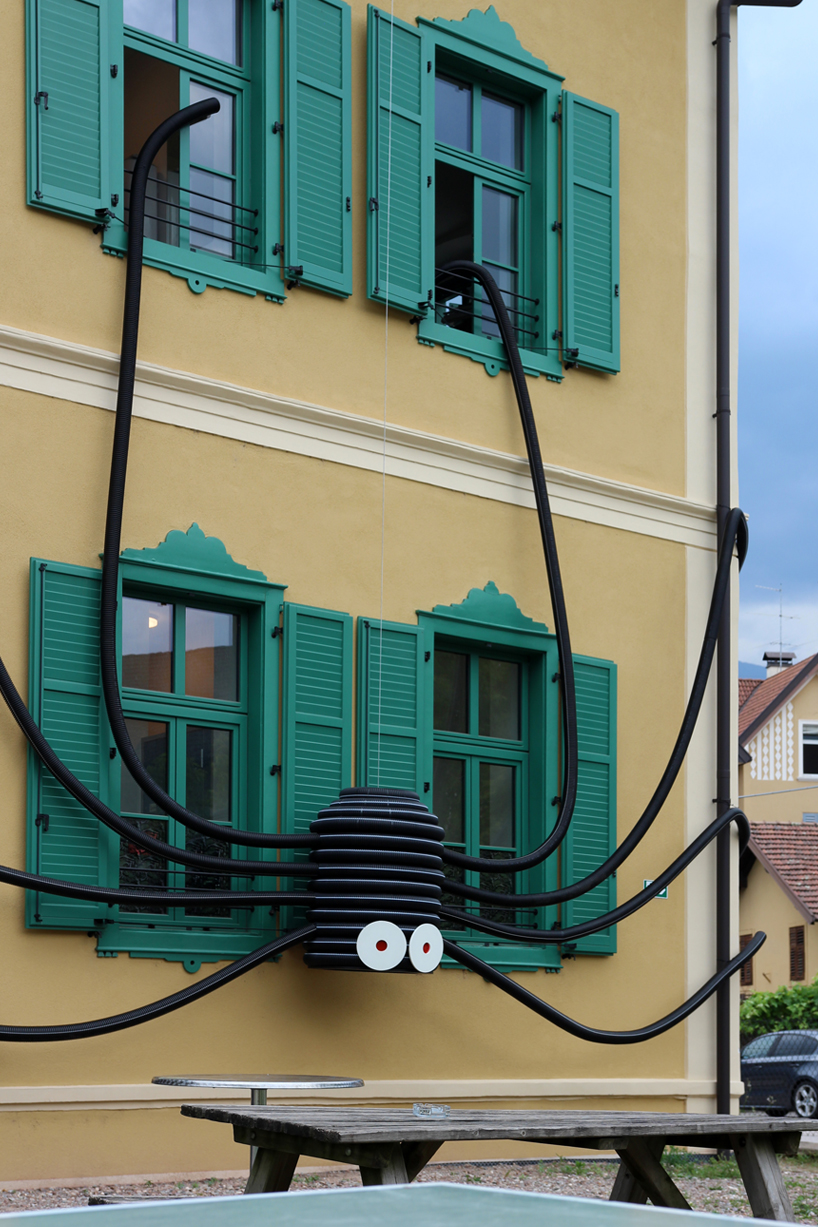 moradavaga's spider sprawls across facade in italy, reminiscent of an old-school string phone