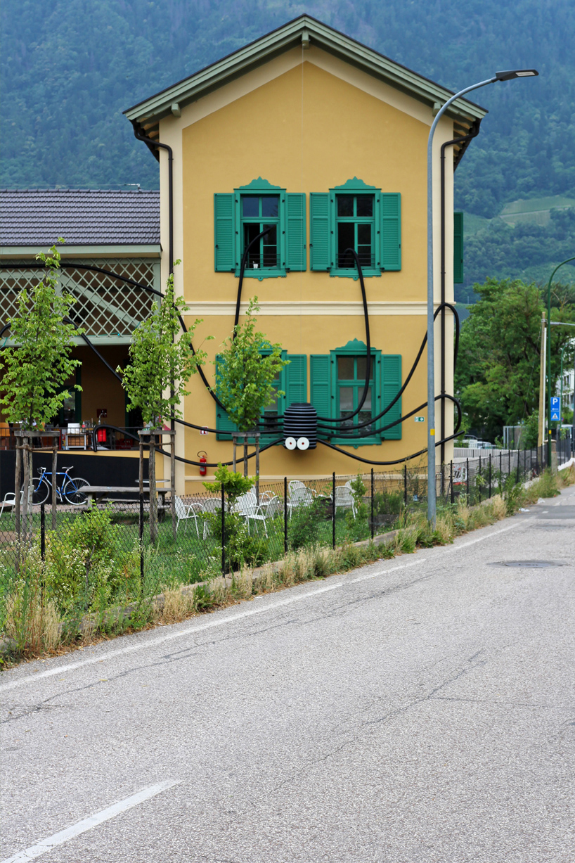 moradavaga's spider sprawls across facade in italy, reminiscent of an old-school string phone