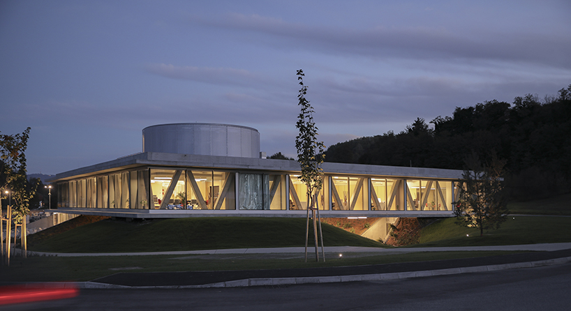 horizontal disk anchors office building by MVA on three greened mounds near zagreb