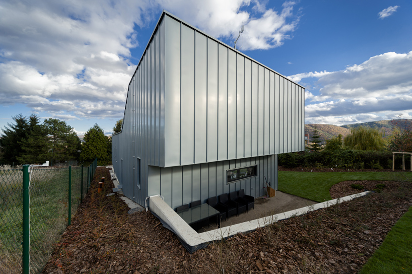 sloped semi cantilever house by grido architektura