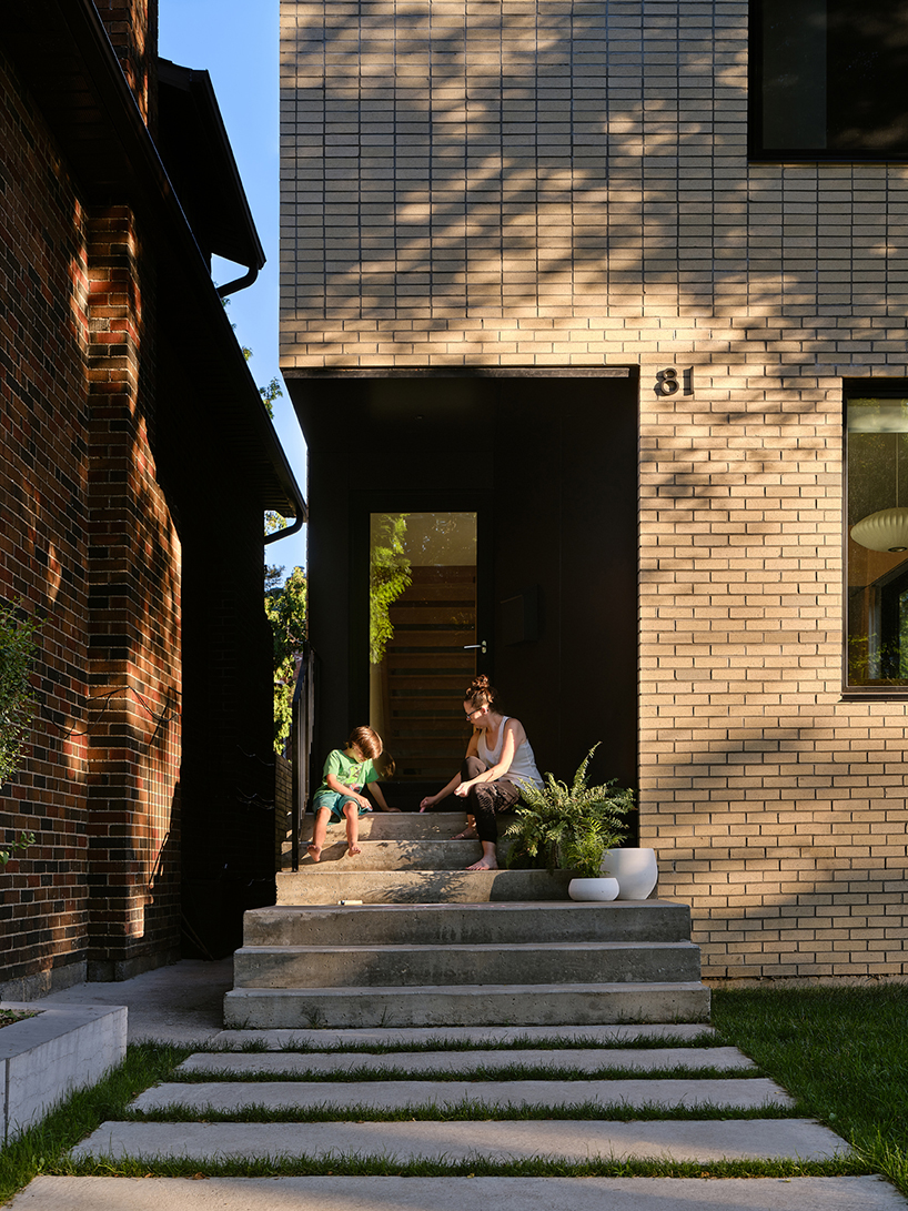brick residence's sloping roof shields recessed outdoor balcony in toronto