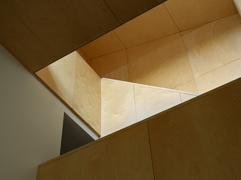 brick residence's sloping roof shields recessed outdoor balcony in toronto