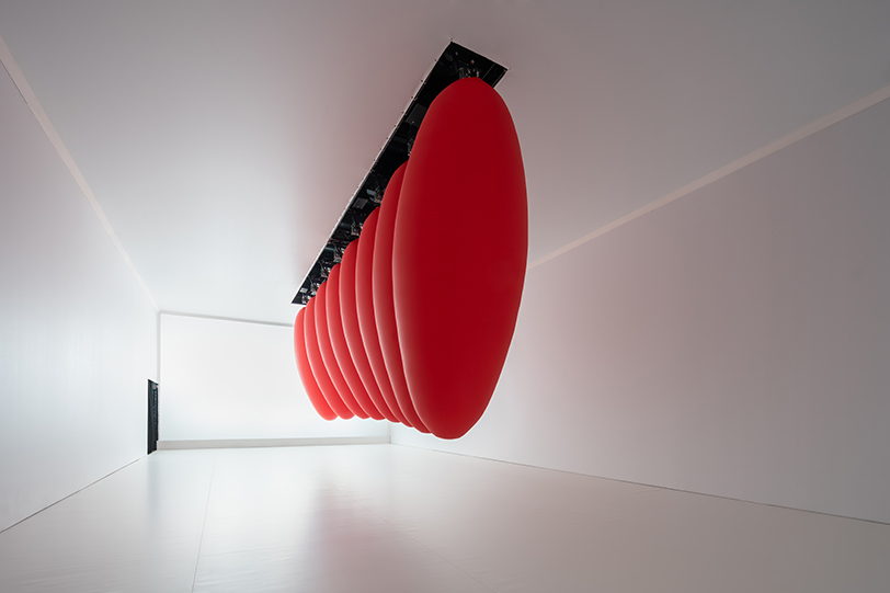 eight suspended red ovoids by SpY dance in pendular sequences