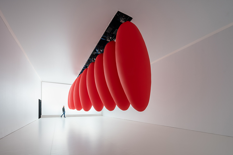 eight suspended red ovoids by SpY dance in pendular sequences