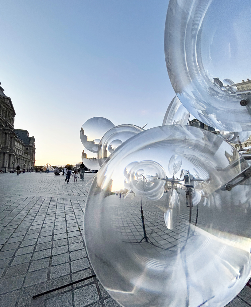 kinetic cloud's floating lenses by vincent leroy deform louvre's facade