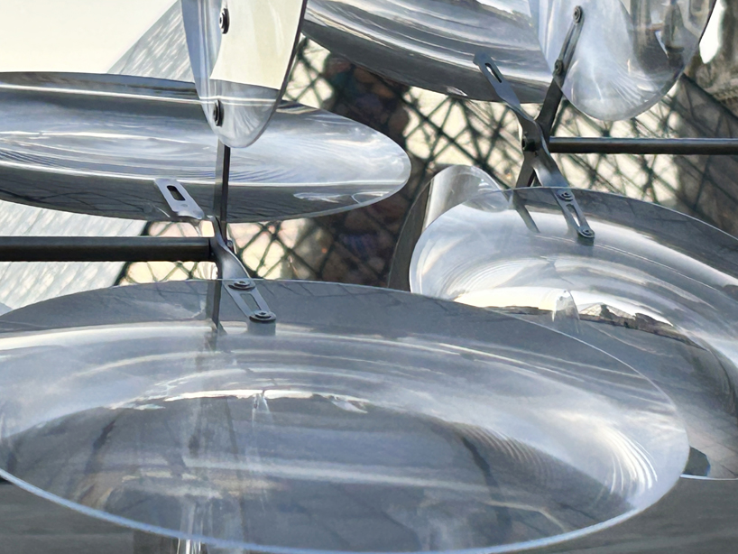 kinetic cloud's floating lenses by vincent leroy deform louvre's facade
