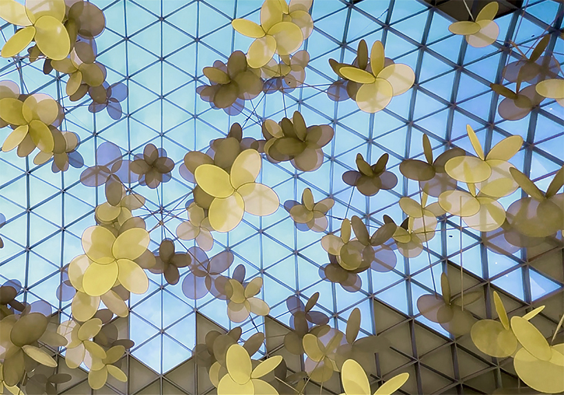 vincent leroy's kinetic installation of metallic mesh flowers floats above hainan island in china