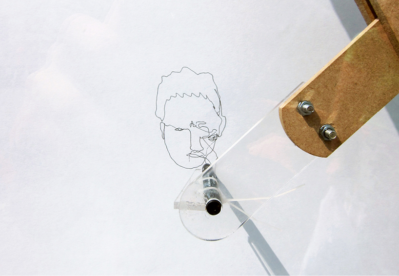 portrait pantograph invites public to draw faces on a window
