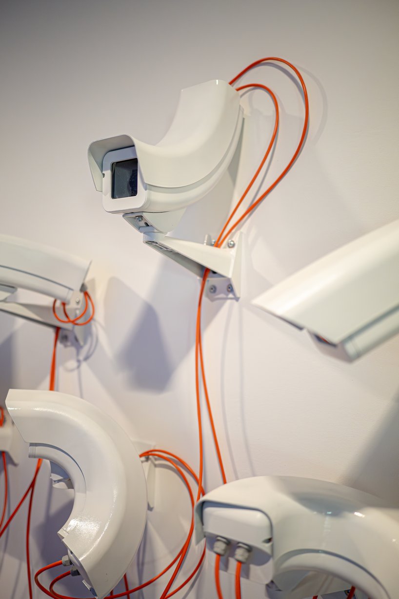 jakub geltner bends surveillance cameras into curved installations for exhibition in belgium