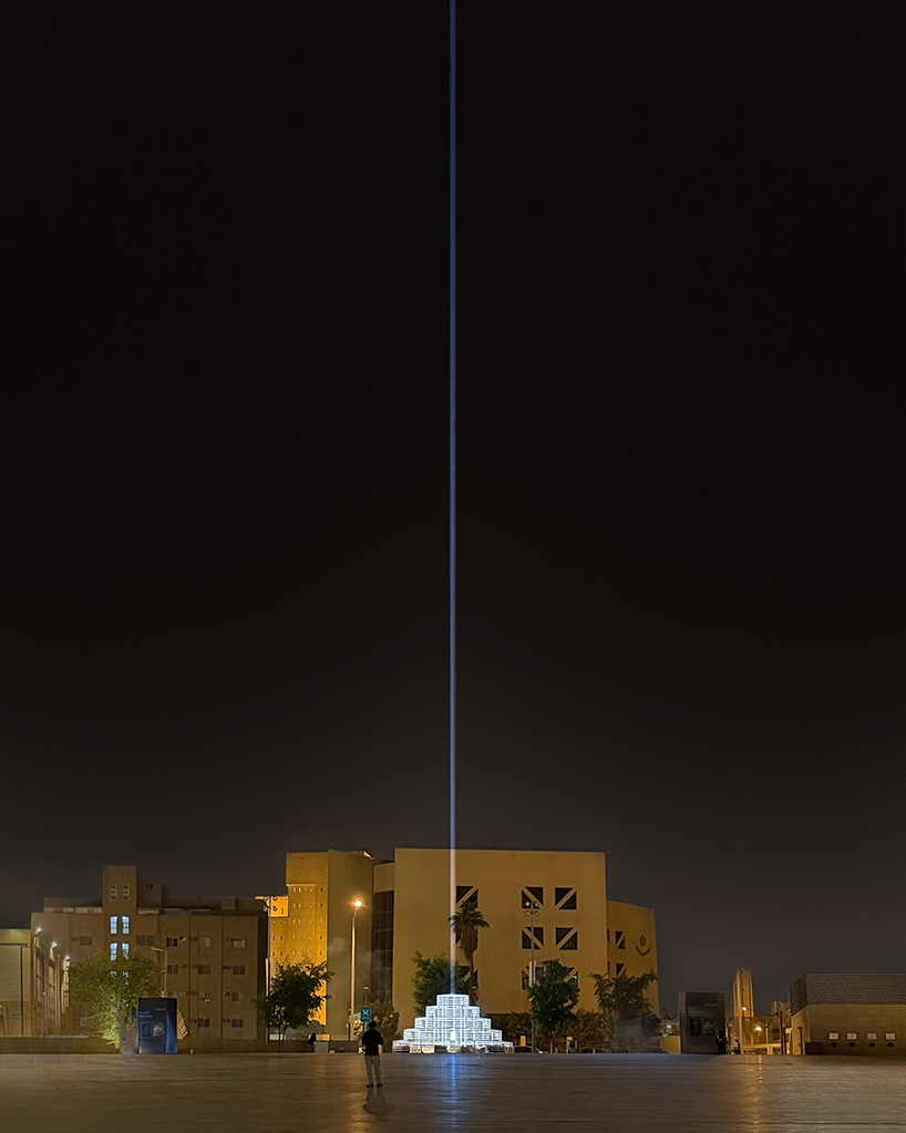 reflective pyramidal monument emits sky-tracing beam of white light in saudi arabia