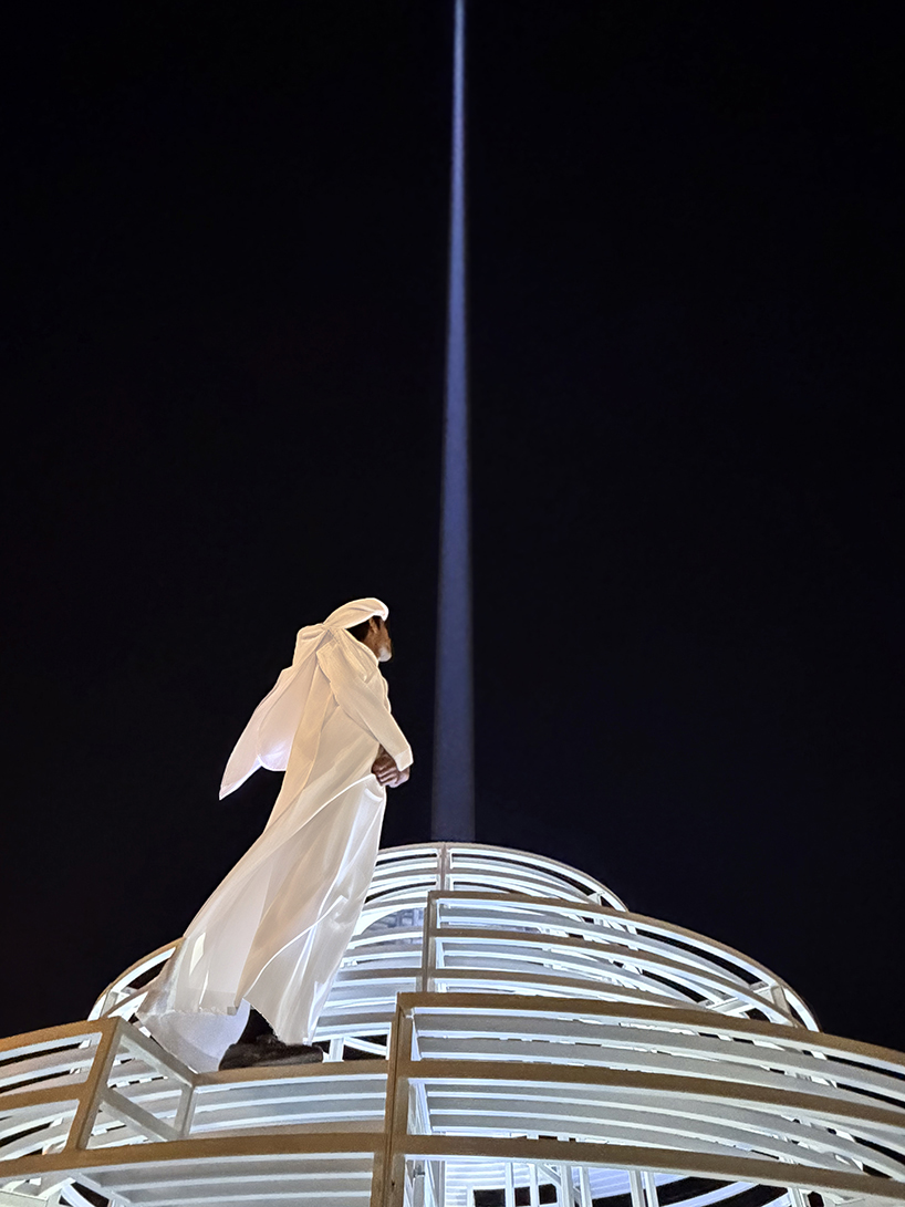reflective pyramidal monument emits sky-tracing beam of white light in saudi arabia