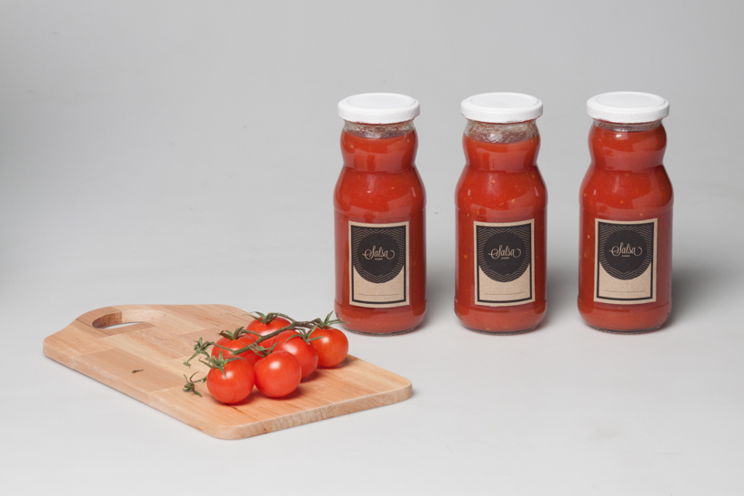 salsa maker squeezes tomatoes to produce traditional home-made sauce