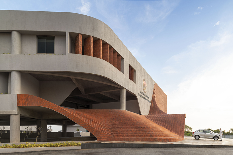 undulating steps clad in red terracotta bricks outline architecture school's entrance in india