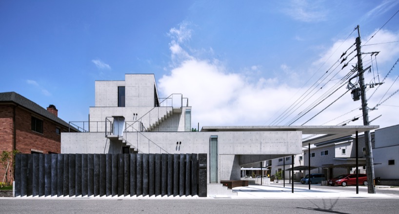 Aleros de hormigón y paredes colgantes rodean casas en Fukutsu, Japón