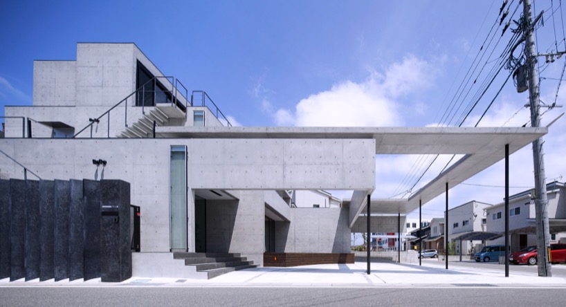 Aleros de hormigón y paredes colgantes rodean casas en Fukutsu, Japón