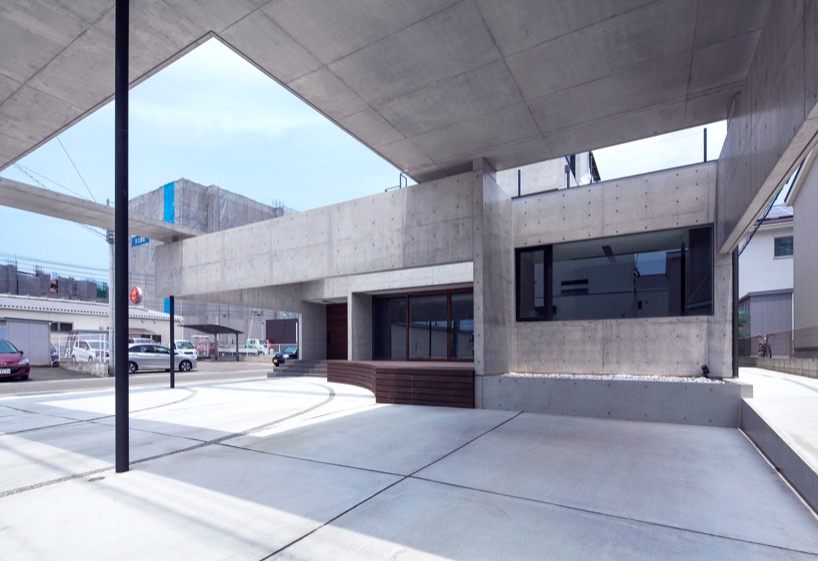 Aleros de hormigón y paredes colgantes rodean casas en Fukutsu, Japón