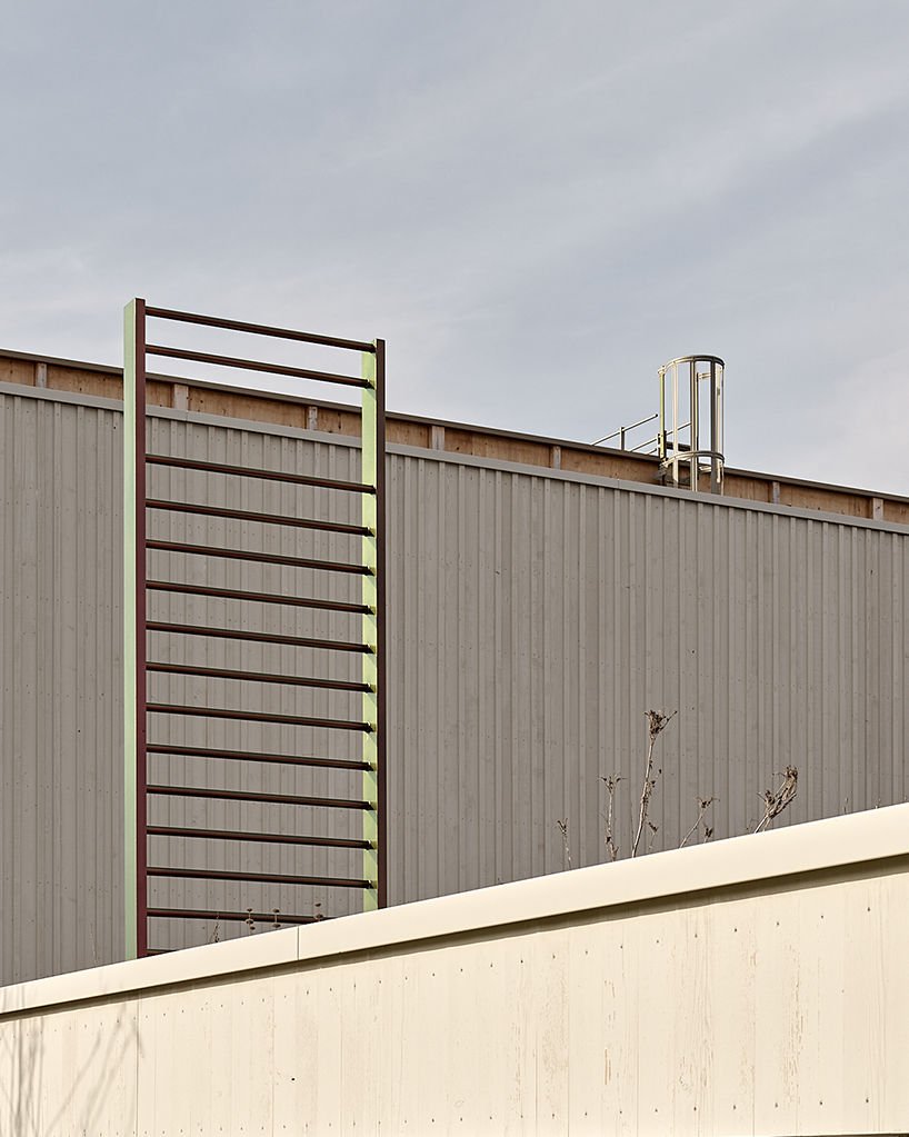 vertical timber construction shapes twin stacked sports halls in switzerland by kit