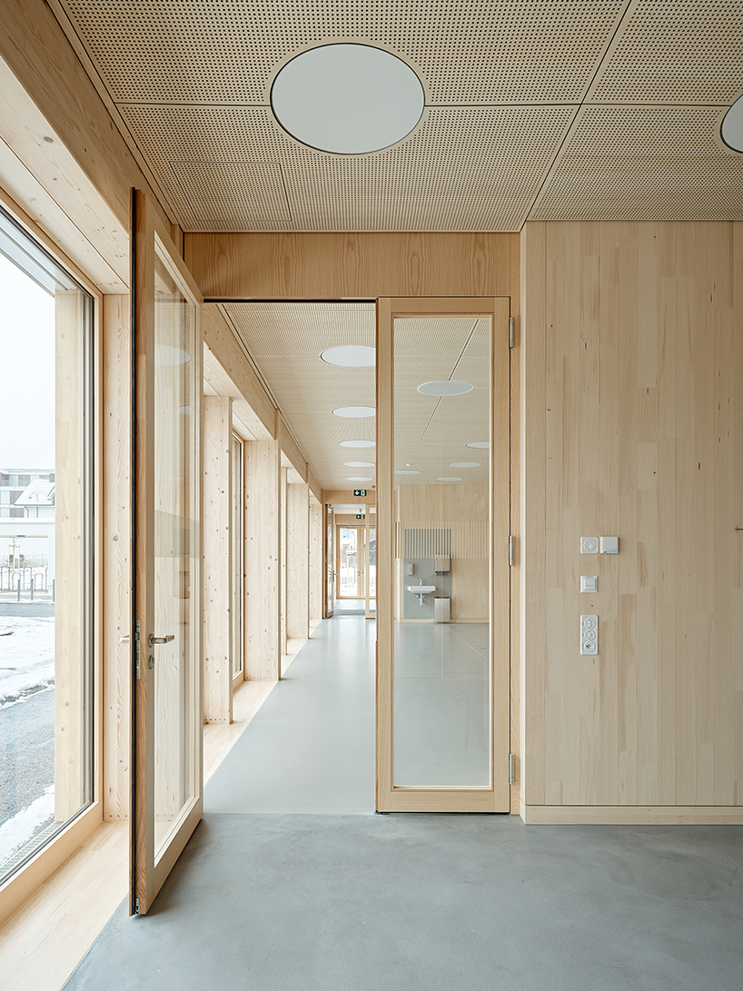 vertical timber construction shapes twin stacked sports halls in switzerland by kit