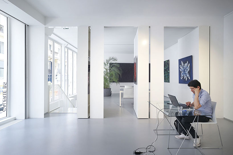 pivoting bookshelves turn this office in paris into a gallery, by hugoo and brillet