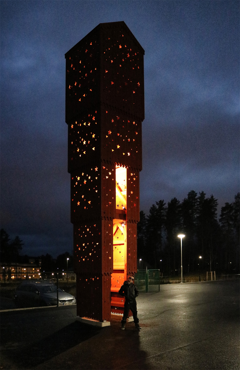 The sculpture of stacked houses in the school yard at UMA is illuminated by cut-out stars