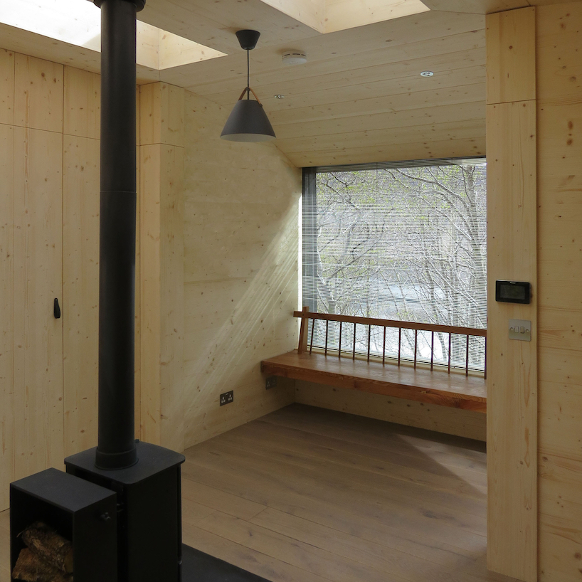 curved larch-clad tree house hovers above steep hillside in the scottish highlands