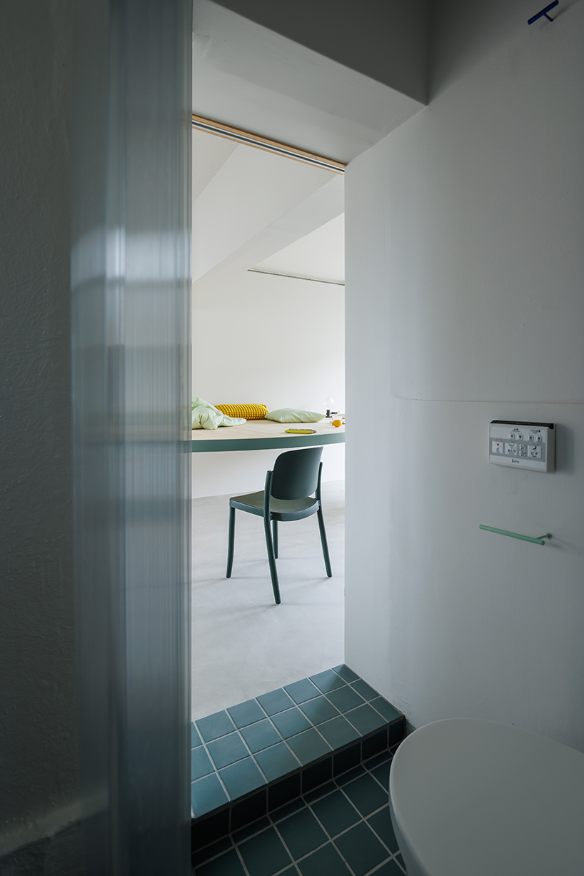 giant blue-green semicircular table by tato architects reorganizes kyoto apartment - 6