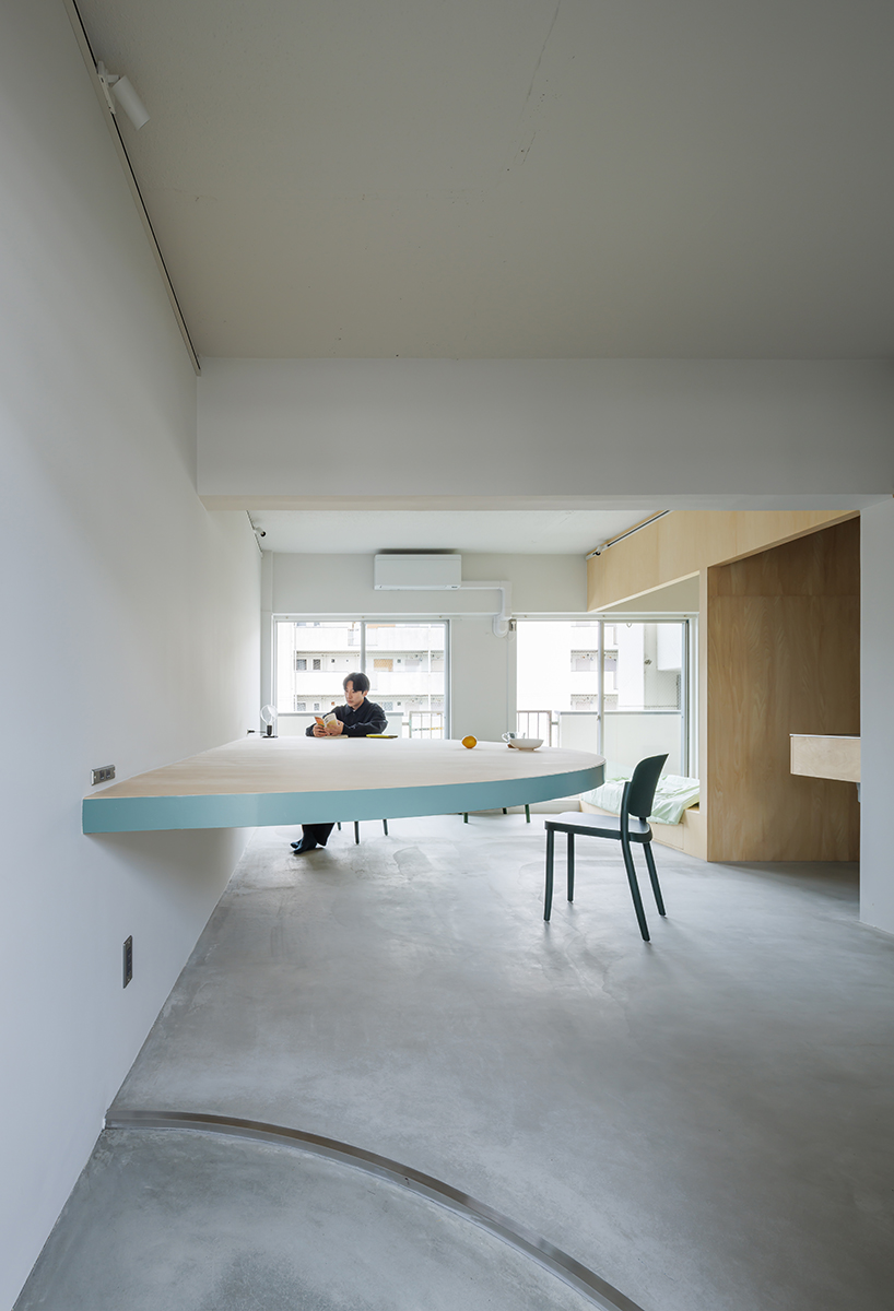 giant blue-green semicircular table by tato architects reorganizes kyoto apartment - 4