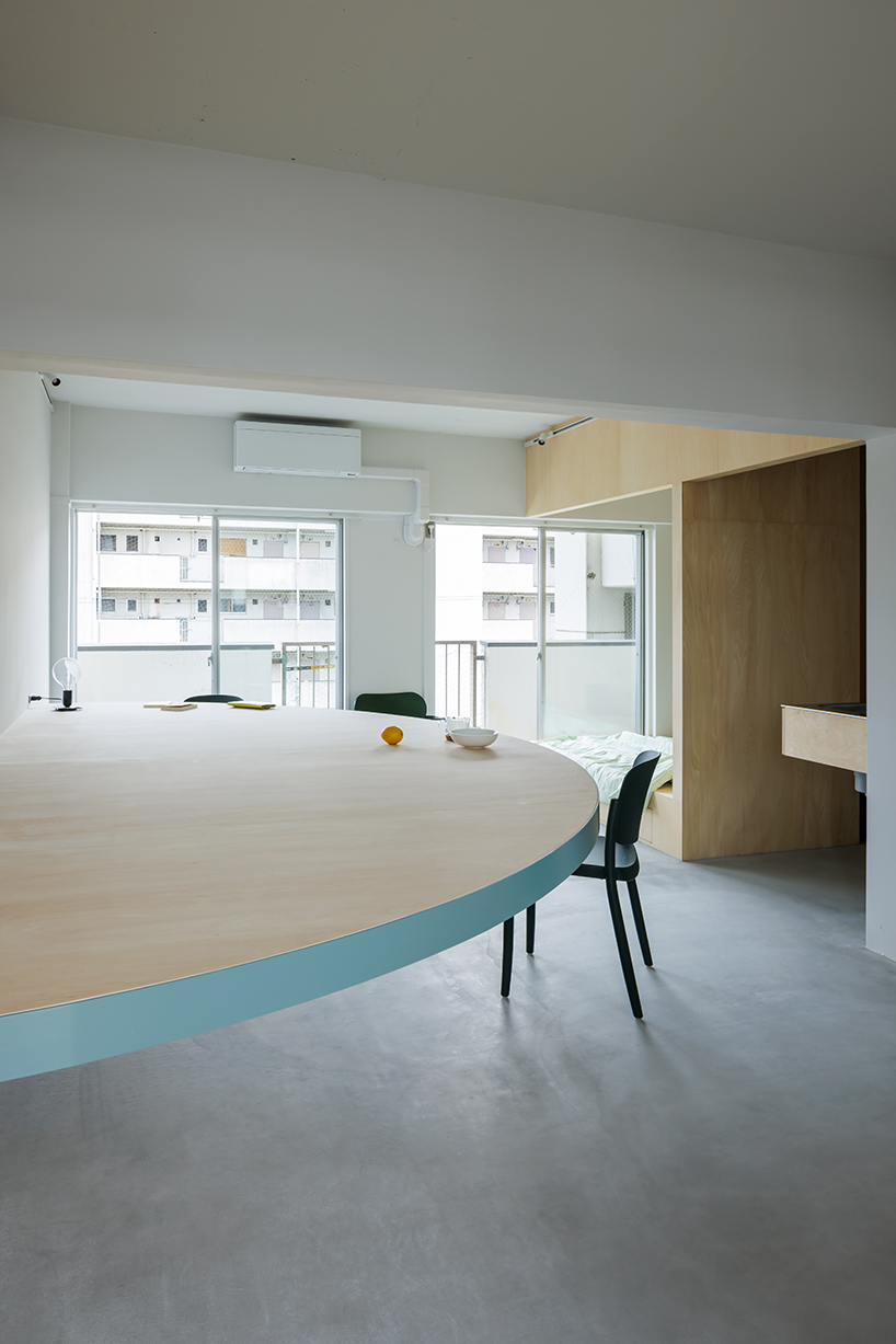 giant blue-green semicircular table by tato architects reorganizes kyoto apartment - 5