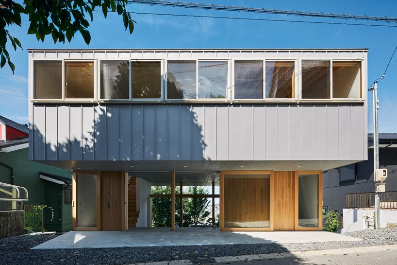 masaki ihara integrates house with tiered foundation into japanese hillside