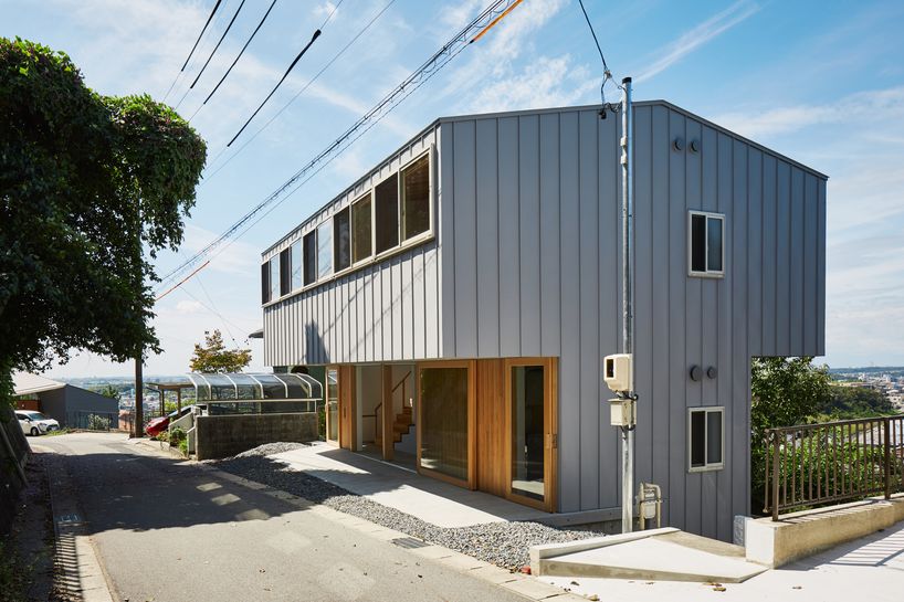 masaki ihara integrates house with tiered foundation into japanese hillside