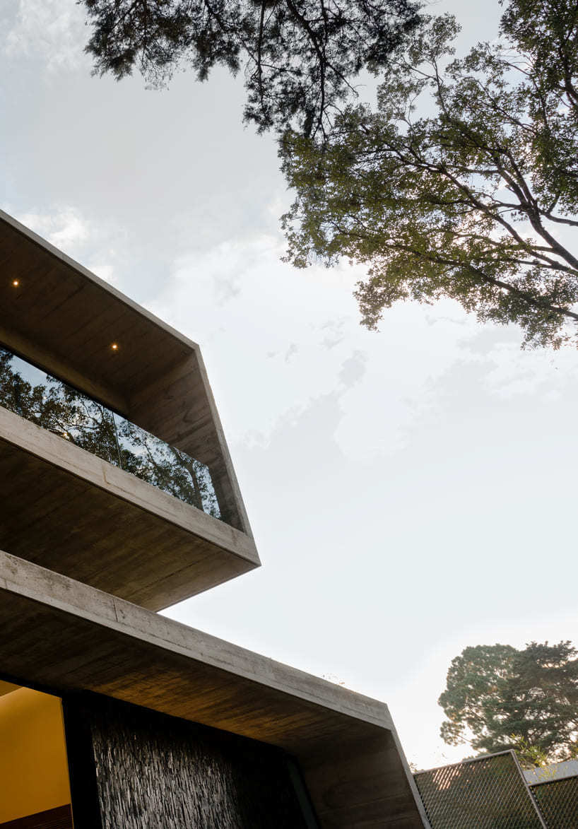 paz arquitectura's exposed concrete house in guatemala contrasts with surrounding woods