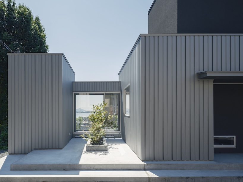 glazed passage frames lake views through this compact japanese house - 2